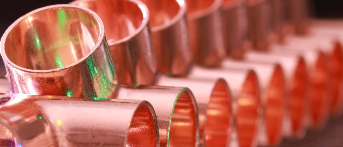 Row of copper pipe fittings laid out