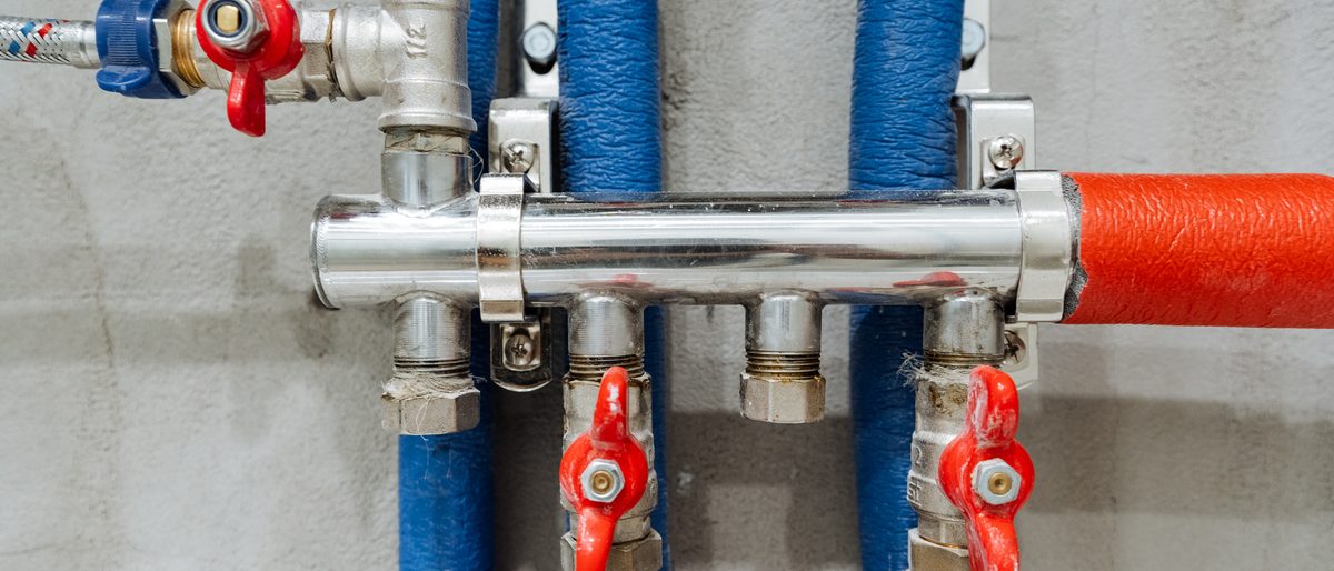 Steel manifold with red and blue insulated pipe runs and valve handles
