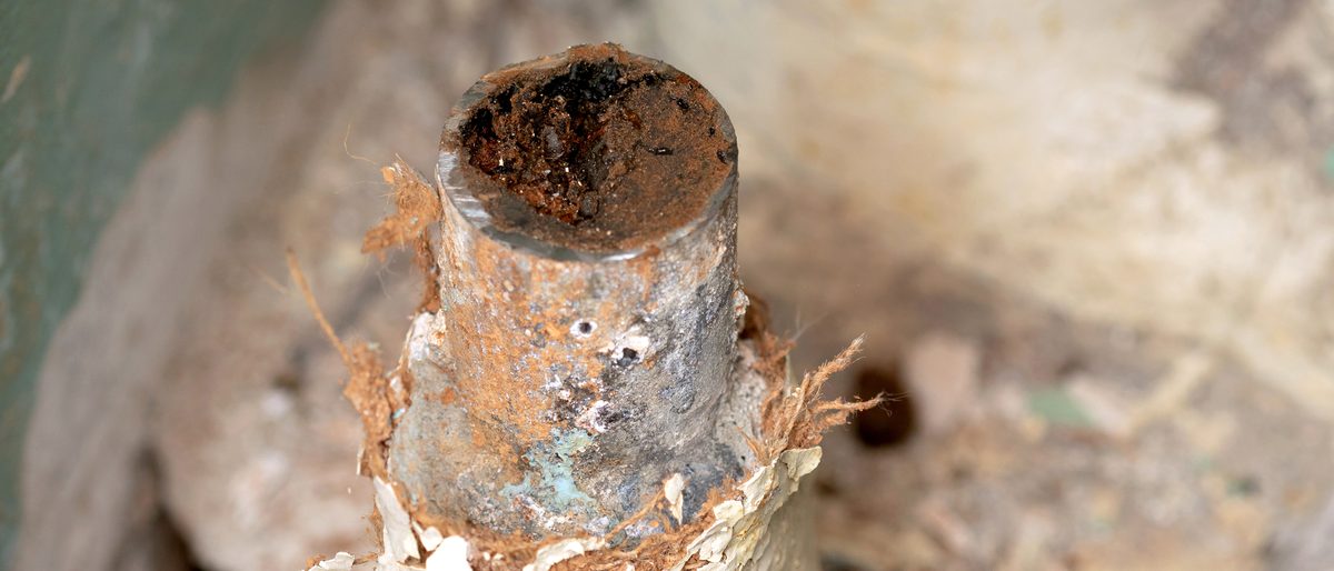 Cut section of old water pipe almost closed by rust